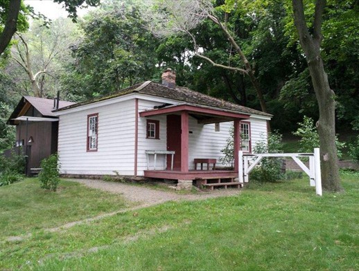 cottagepic shows cottage in summer with trees behind it